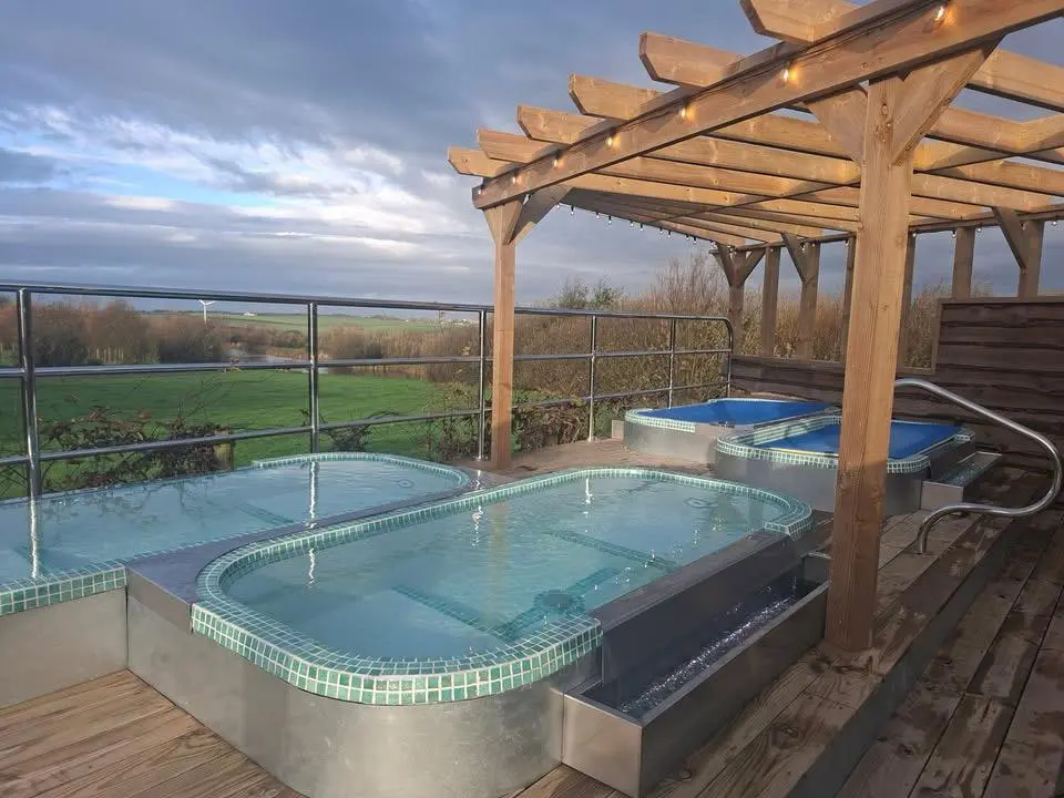 Handmade hot tubs overlooking Cornish countryside at Little Pig Wellness near Bude, part of sauna and cold plunge experience