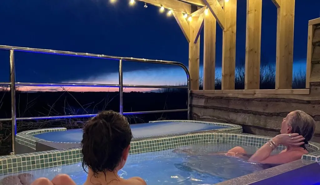 Guest relaxing in the hot tub after contrast therapy in countryside setting