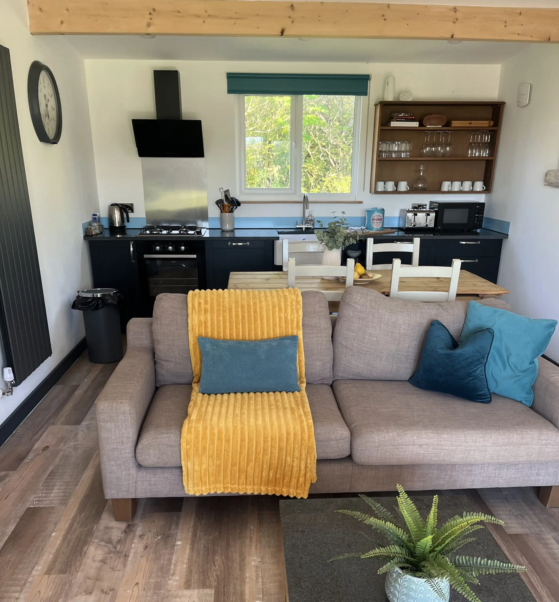 Open-plan self-catering lodge with fully equipped kitchen and comfortable living area at Little Pig Wellness near Bude, North Cornwall.